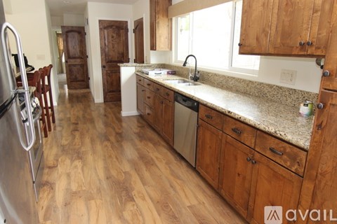 A kitchen with wooden cabinets and a granite countertop.
