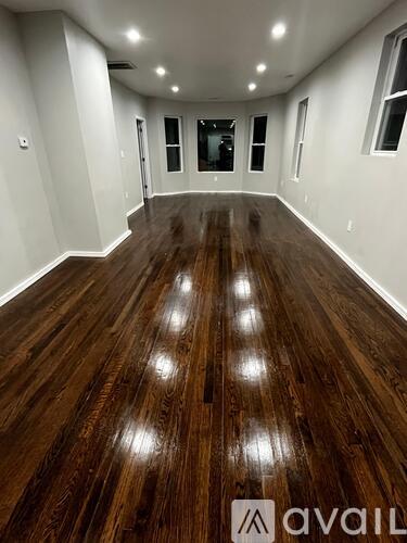 A room with wooden flooring and white walls.