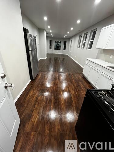 A kitchen with a wooden floor and white cabinets.