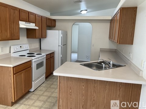 A kitchen with wooden cabinets and a white stove top oven.