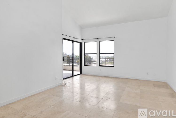 A spacious room with tiled flooring and sliding glass doors.