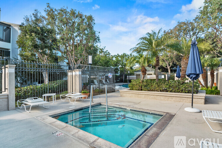 A pool surrounded by a fence and trees.