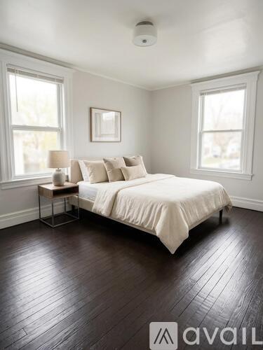 A bedroom with a bed, nightstand, and window.