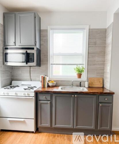 A kitchen with a white stove top oven and a microwave above it.