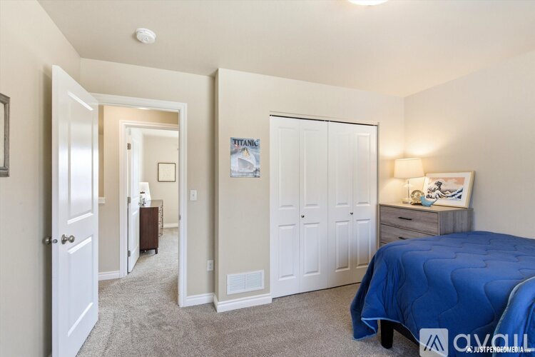 A bedroom with a blue bed and a white door.
