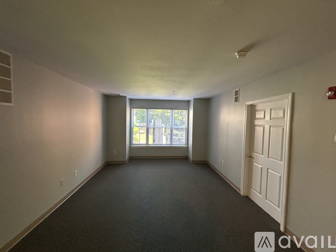 A spacious room with a door and a window.