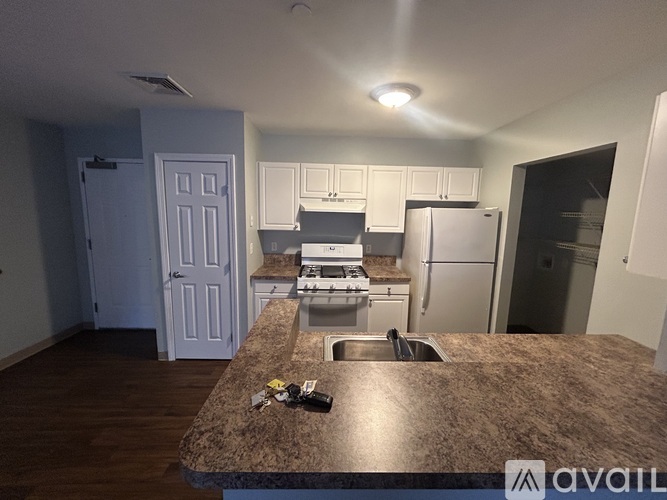 A kitchen with granite countertops and white cabinets.