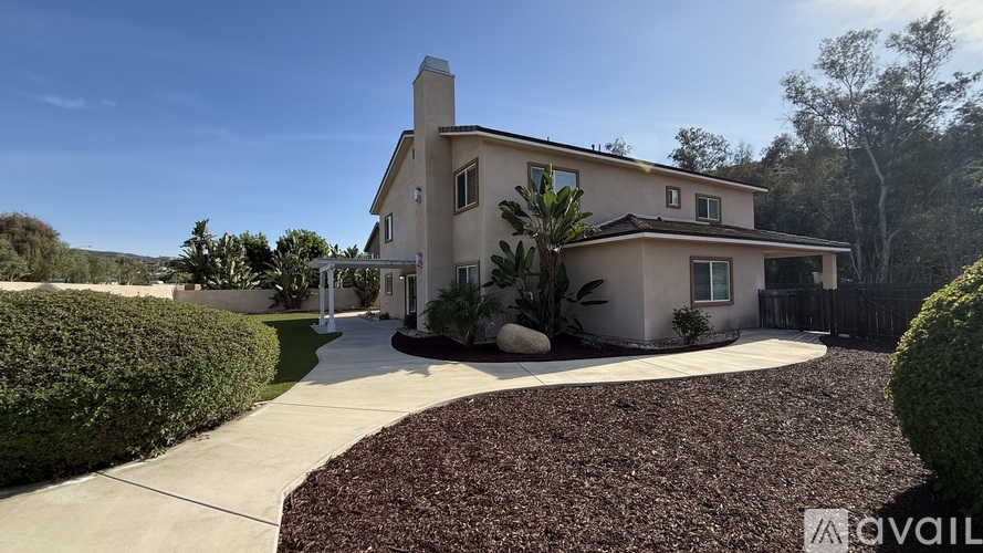A house with a driveway and landscaping in front.