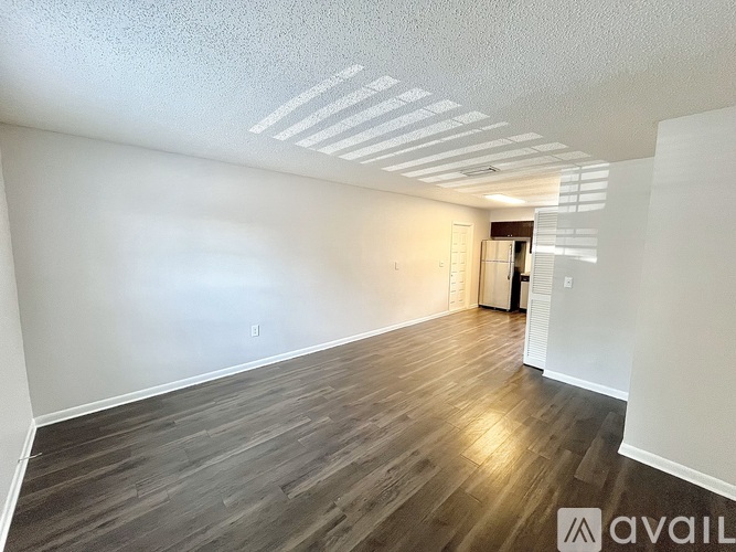 A room with wooden flooring and white walls is available for rent.