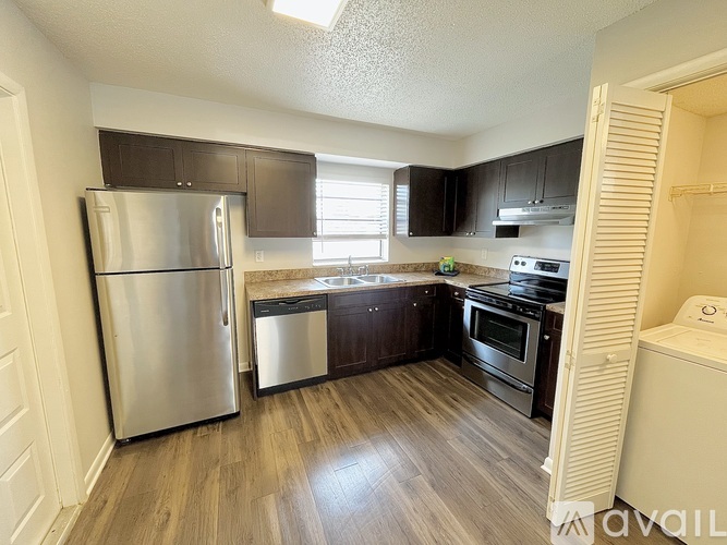 A kitchen with a refrigerator, sink, and oven.