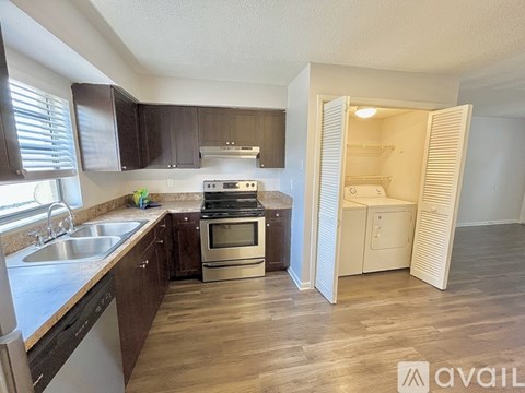 A kitchen with dark brown cabinets and a stainless steel oven.