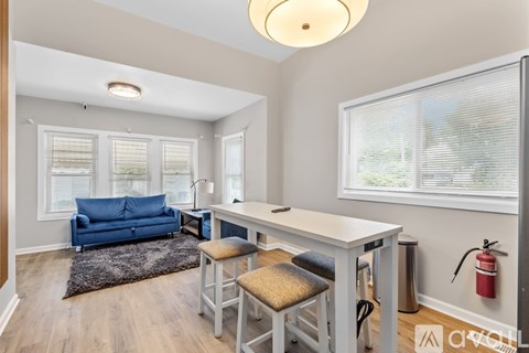 A living room with a blue couch, a white table, and a fire extinguisher on the wall.