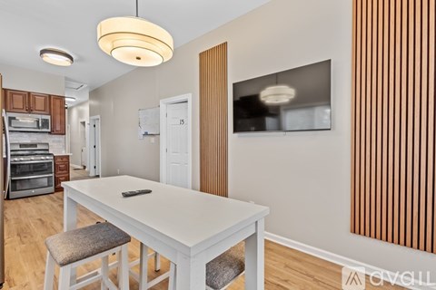 A modern kitchen with a white table and wooden cabinets.