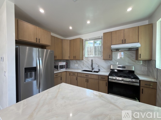 A kitchen with wooden cabinets and a stainless steel refrigerator.