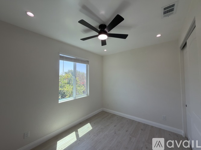 A room with a ceiling fan and a window.