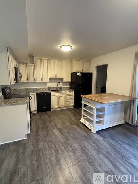 A kitchen with a black fridge and a white counter top.