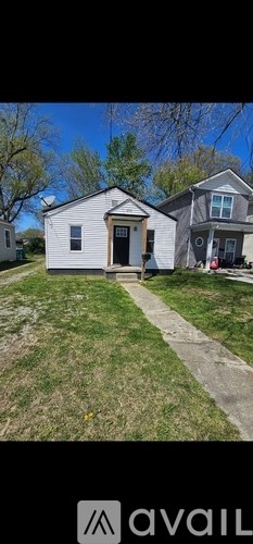 A small white house with a brown door and a small porch.
