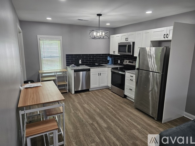 A modern kitchen with a wooden table and stainless steel appliances.