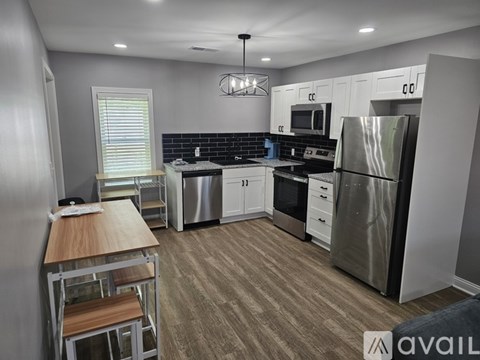 A modern kitchen with a wooden table and stainless steel appliances.
