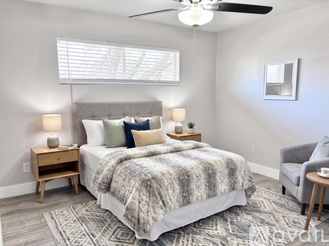 A bedroom with a large bed and a ceiling fan.