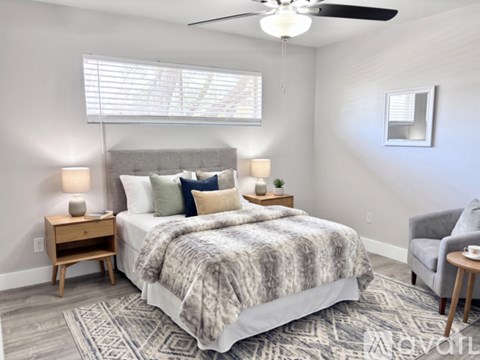 A bedroom with a large bed and a ceiling fan.