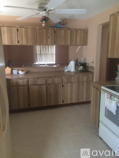 A kitchen with wooden cabinets and a white refrigerator.