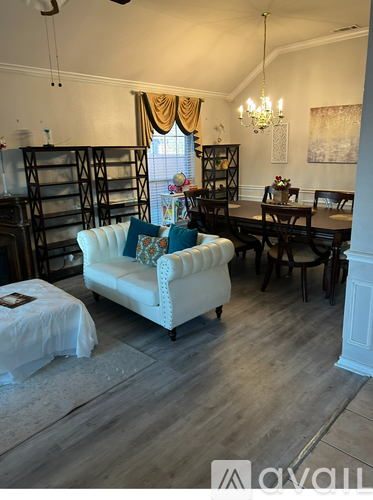 A living room with a white sofa and a wooden floor.