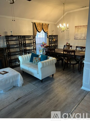 A living room with a white sofa and a wooden floor.