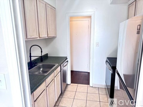 A kitchen with a sink and a refrigerator.