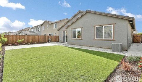 A house with a grey exterior and a green lawn in front.