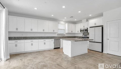 A kitchen with white cabinets and a central island.