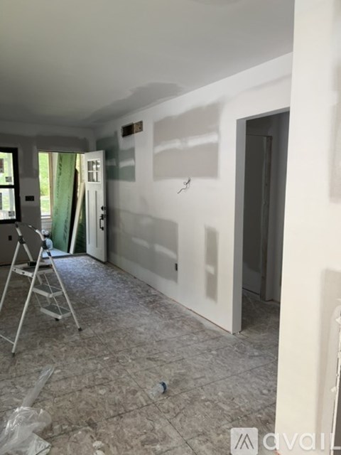 A room with a ladder and a wall with a lot of white space.