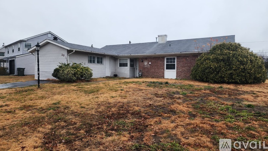 A house with a white exterior and a brick chimney is available for sale.