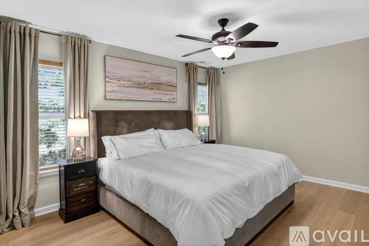 A bedroom with a large bed and a ceiling fan.