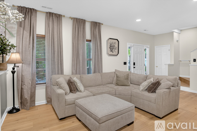 A living room with a large sectional sofa and ottoman.