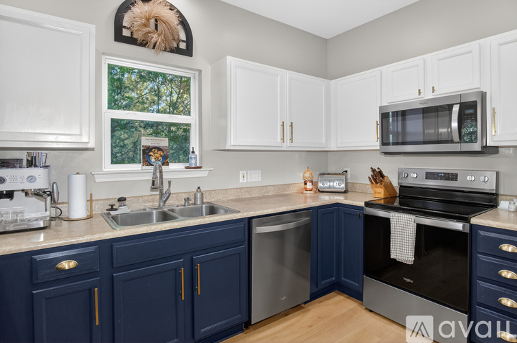 A kitchen with white cabinets and a window.