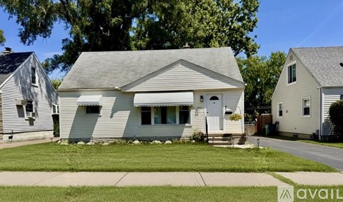 A house with a grey roof and white walls is available for rent.