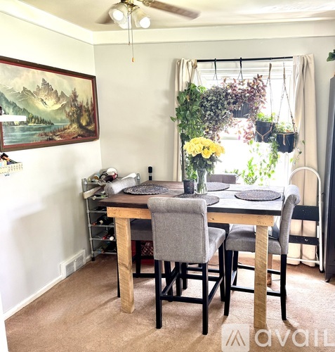 A dining room with a wooden table and grey chairs.