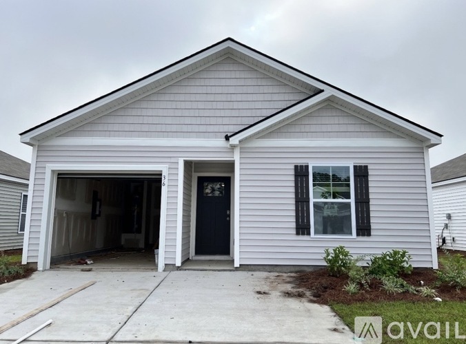 A house with a garage and a black door is available for rent.