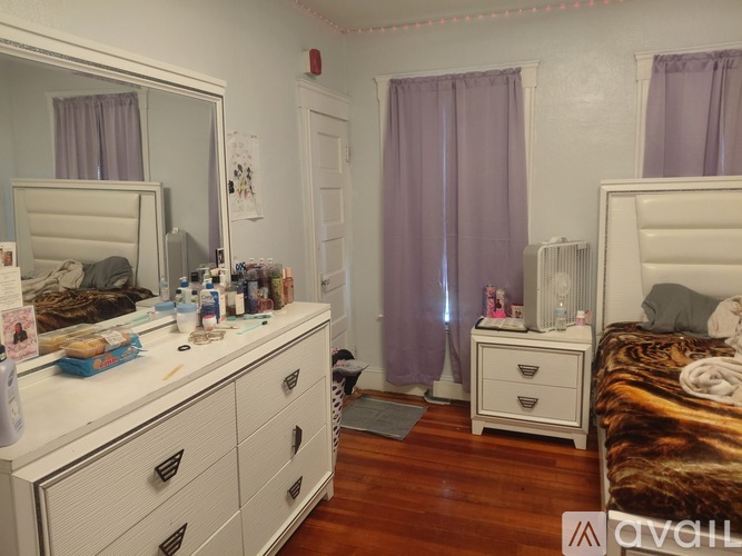 A bedroom with a white vanity and a bed with a leopard print bedspread.