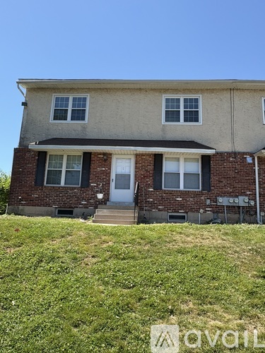 A two-story house with a white door and windows.