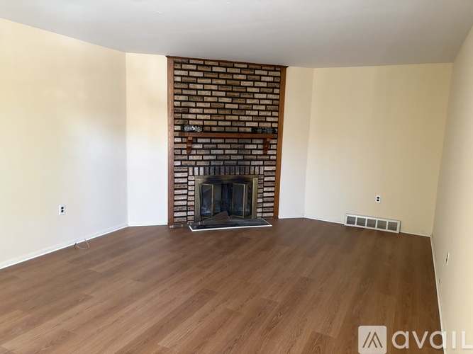A room with a fireplace and wooden floors.