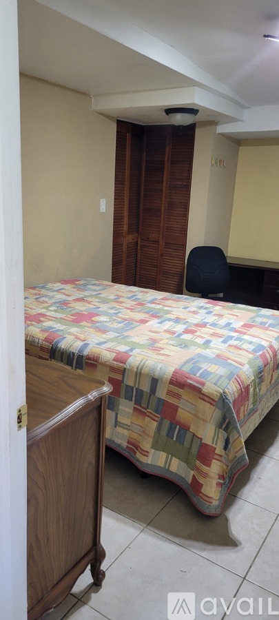 A bedroom with a bed, wardrobe and chair.