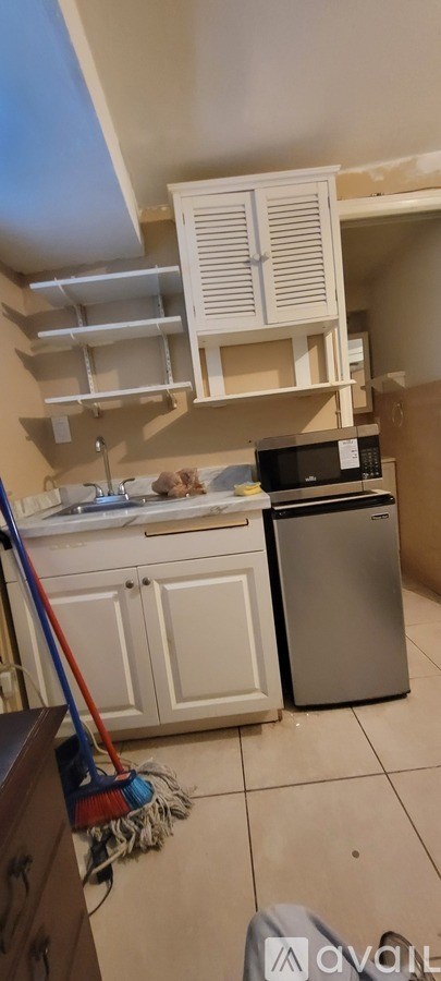 A kitchen with a dishwasher and a broom.
