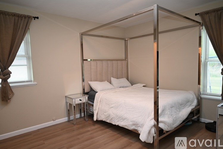 A bedroom with a four poster bed and a small table.