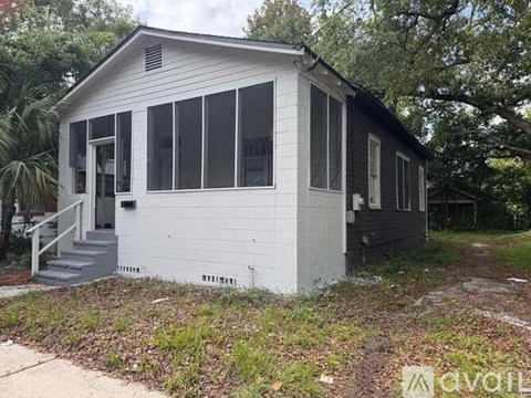 A small white house with a black roof and a grey front door.