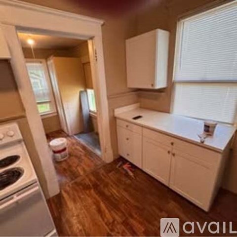 A kitchen with white cabinets and a stove top oven.