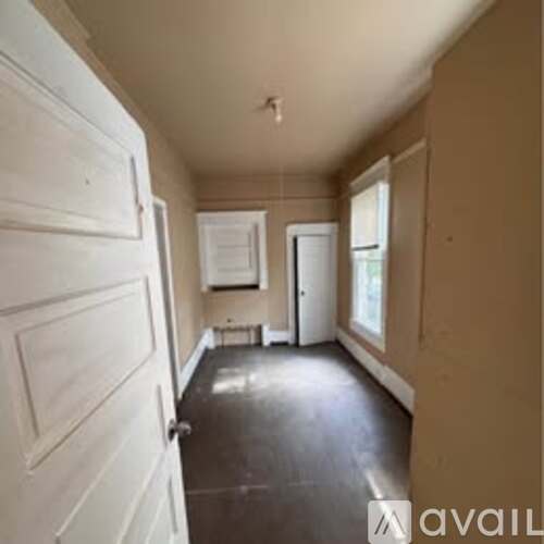 A room with a white door and a window.