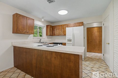 A kitchen with wooden cabinets and a white countertop.