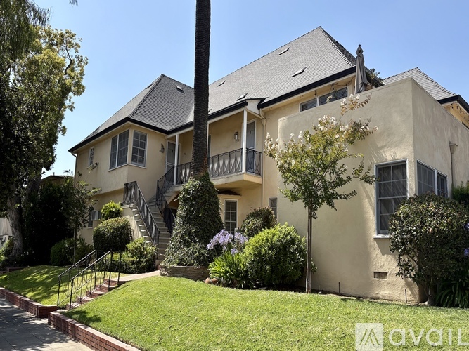 A house with a well-maintained lawn and a tree in front.